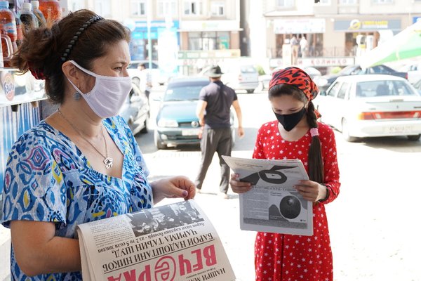 Women reading newspapers with masks during COVID19
