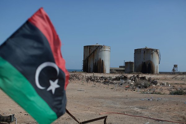 Libyan flag with oil tankers behind 